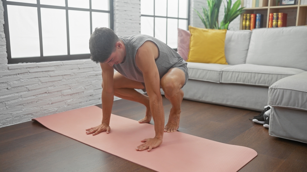 Man doing burpees in his front room