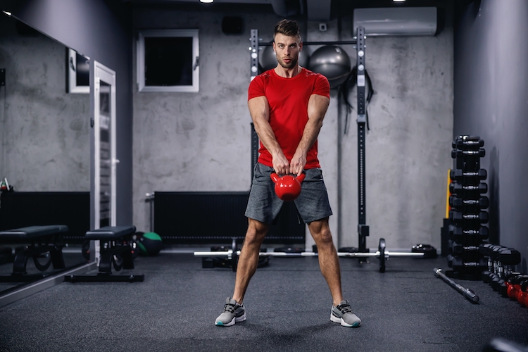 Man in a gym working out with a kettlebell