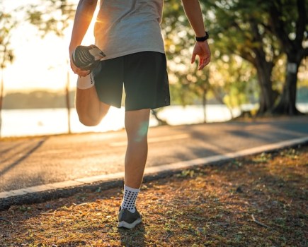 Lower torso of a male runner, stretching