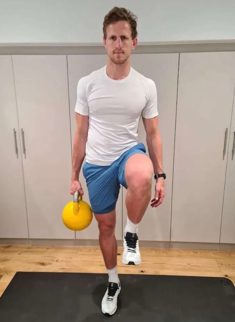 Man performing a dumbbell suitcase march