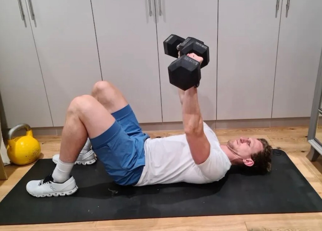 Man performing a dumbbell floor press