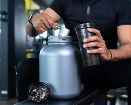 Man filling a bottle with pre-workout powder