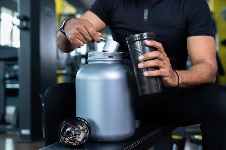Man filling a bottle with pre-workout powder