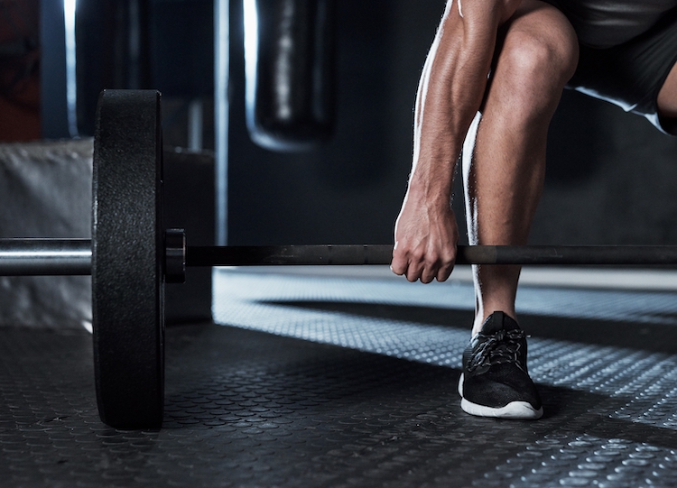 Cropped shot of a man's leg and barbell