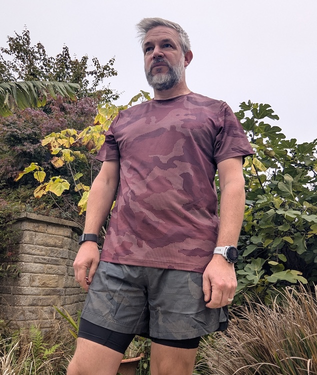 Man in a garden wearing a camo gym shirt and shorts