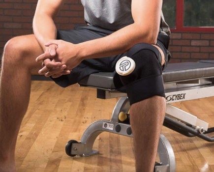 A man sitting on a workout bench with a strapped knee