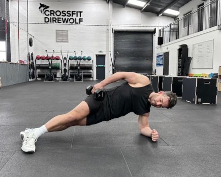 Man performing a sideways dumbbell exercise