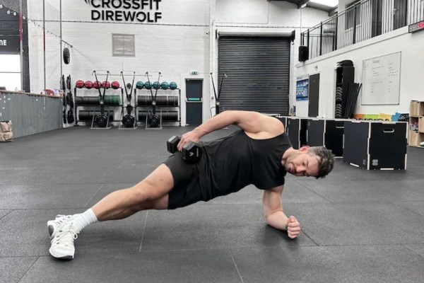 Man performing a sideways dumbbell exercise