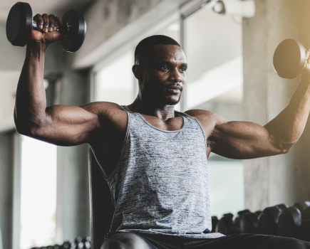 man sat doing the best dumbbell exercises