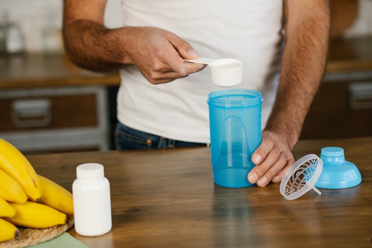 Close-up of a man making a pre-workout drink