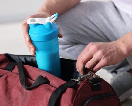Close-up of protein shaker being taken out of a sports bag