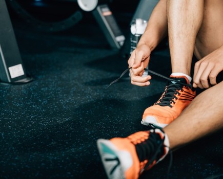 Close up of a man tying his gym shoe laces