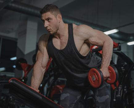 man doing a dumbbell tricep workout in the gym