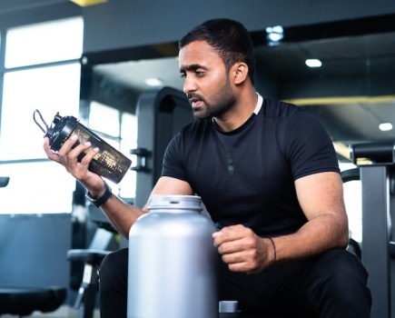 Man about to drink pre-workout in a gym