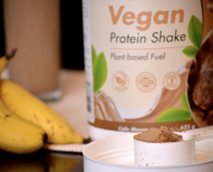 best vegan protein powders on a table with banana