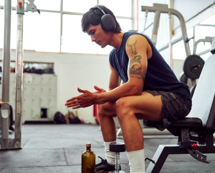 Man sitting in a gym wearing headphones
