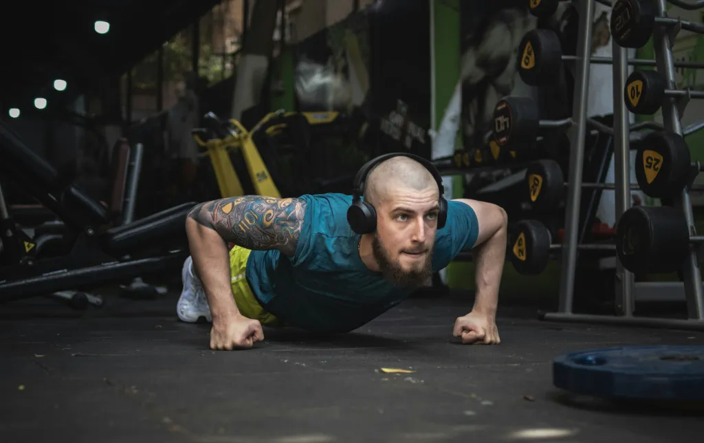 man does press up on firsts while listening to music