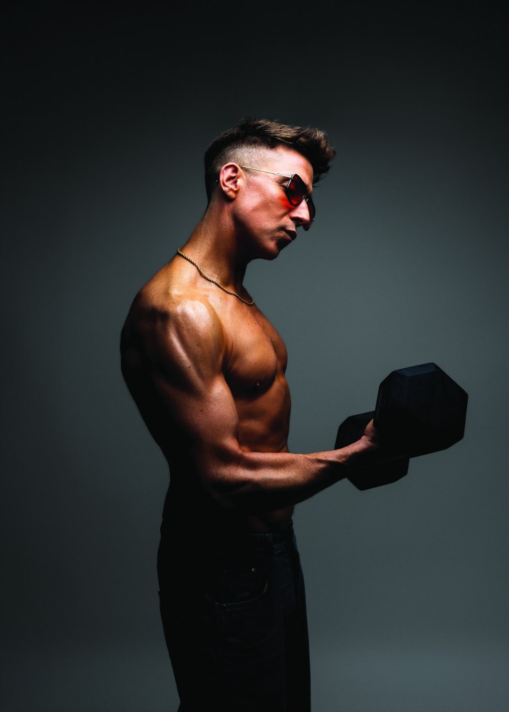 Russell Kane holding weights