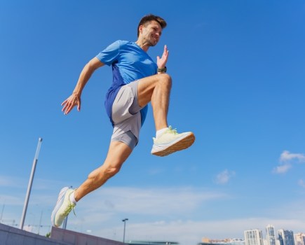 Man leaping in lined running shorts