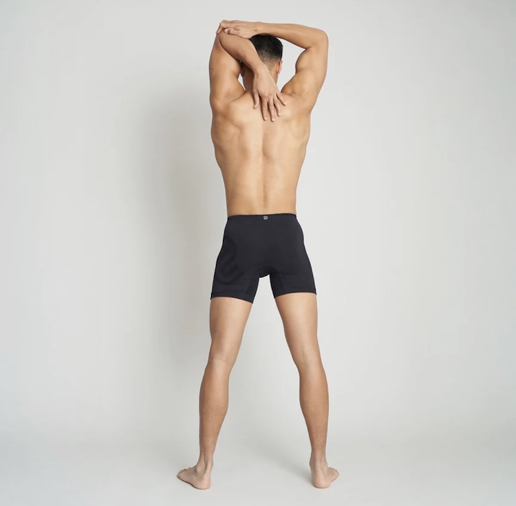 A man stretching wearing boxer shorts