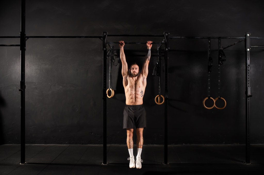 Fit man doing a dead hang
