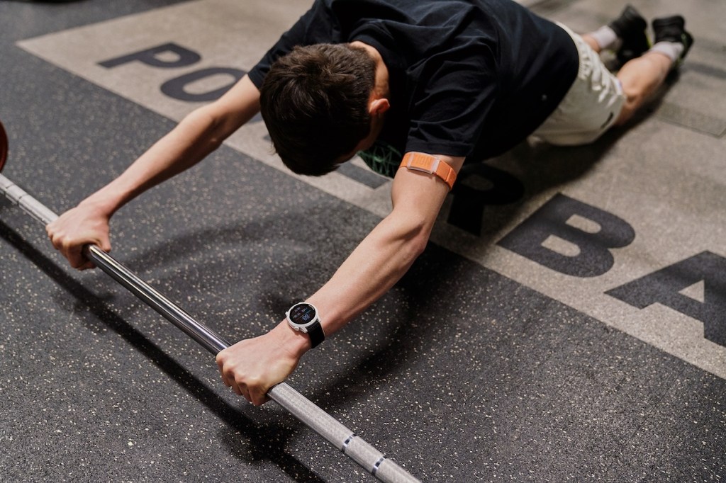 Triathlete performing dumbbell roll-outs in the gym