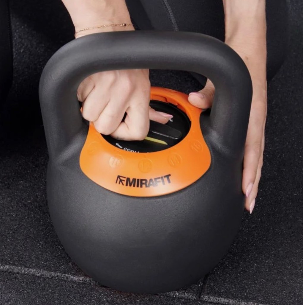 Hands adjusting an adjustable kettlebell