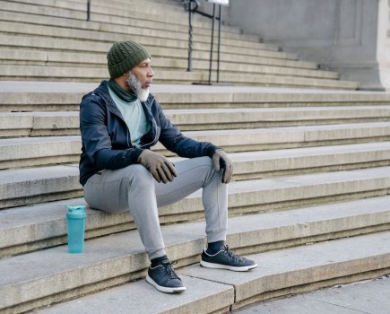 Man in sweatpants sitting on steps