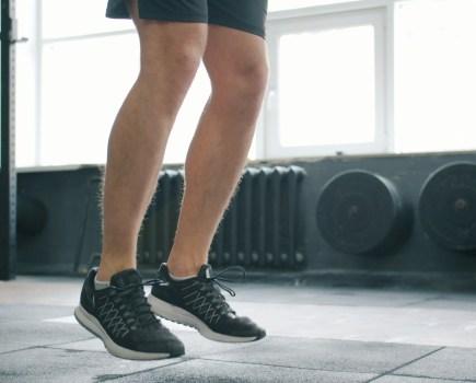 best gym shoes worn by a man jumping inside a gym