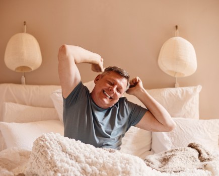 Middle-aged man waking up in the morning happy