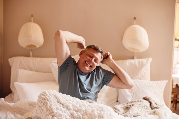 Middle-aged man waking up in the morning happy