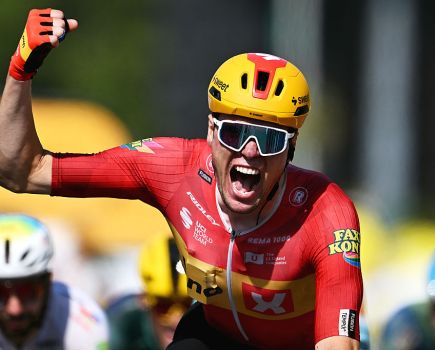 Cyclist Soren Waerenskjold wins at the Tour de France in a sprint finish. He is celebrating as he crosses the line, punching the air with his right arm and hand